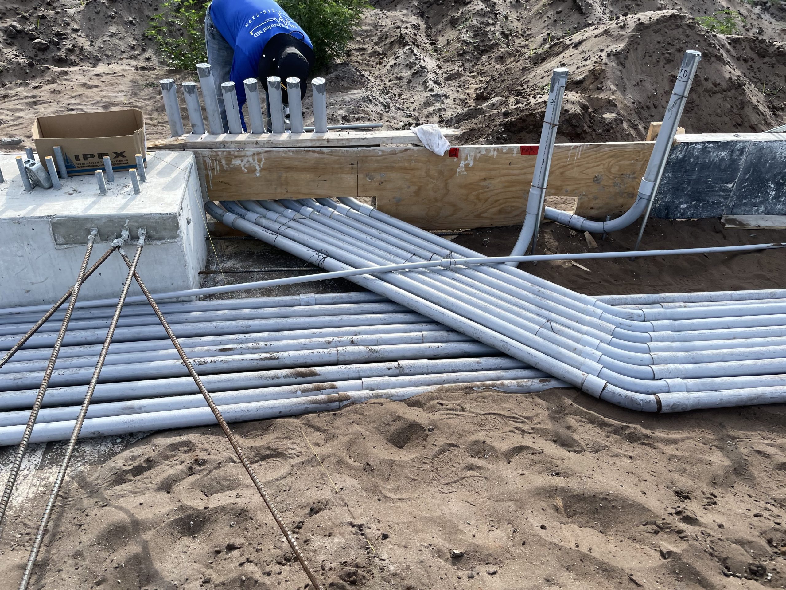 Gray electrical conduit laid out at an unfinished construction site